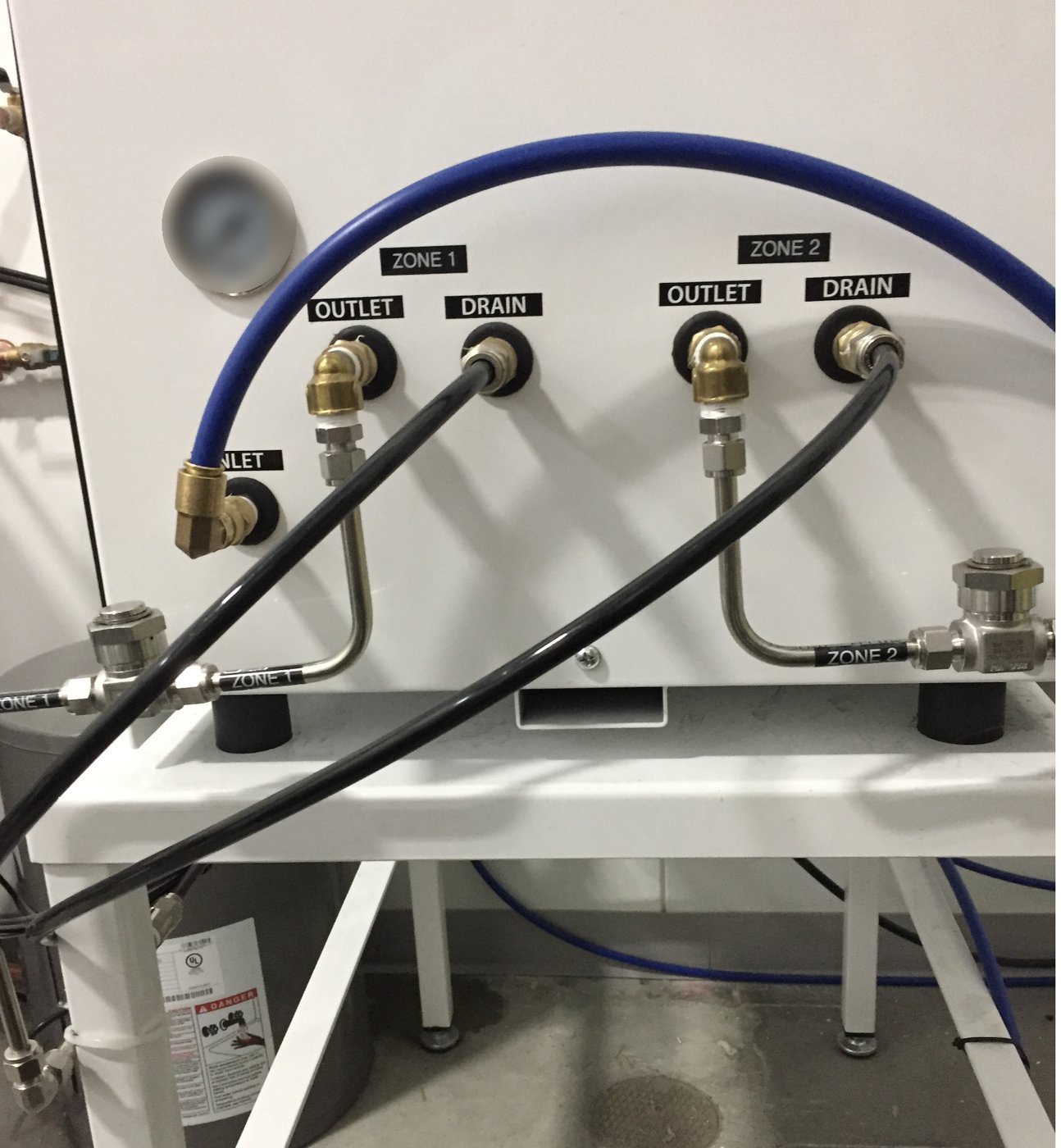Labeled high-pressure outlets and drain connections on the two-zone pump station
