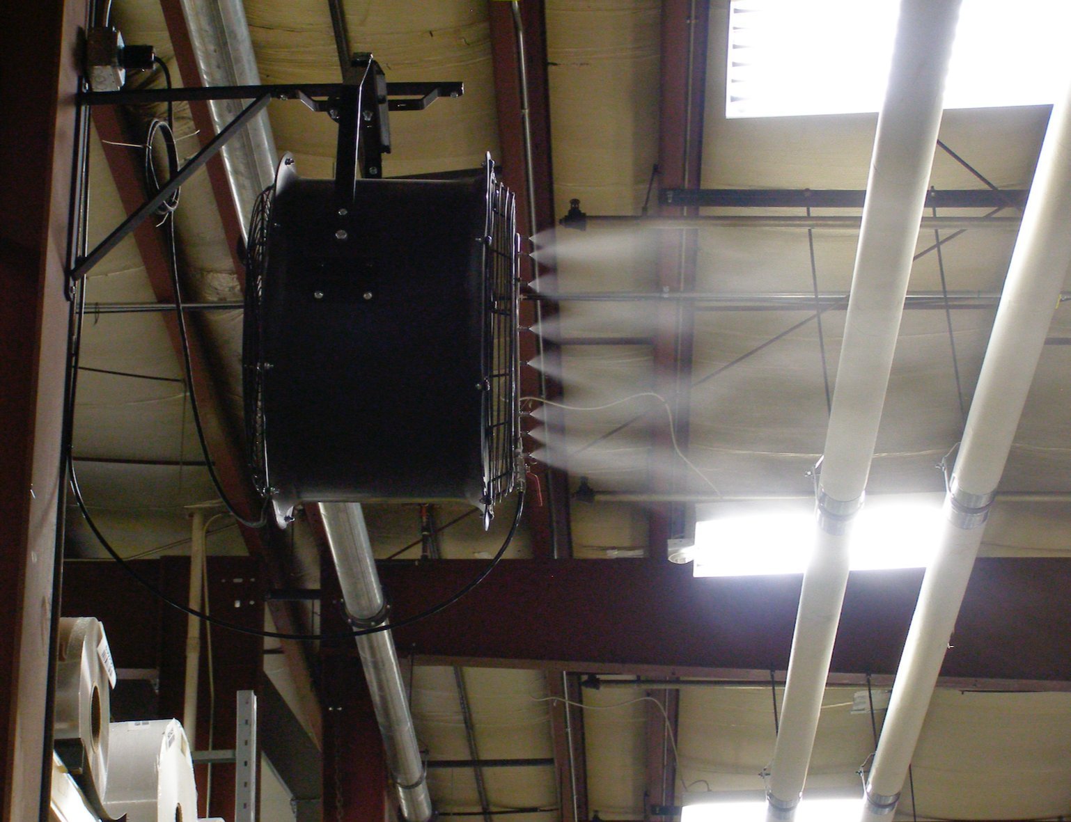 Bracket-mounted misting fan directing fine spray into open ceiling space